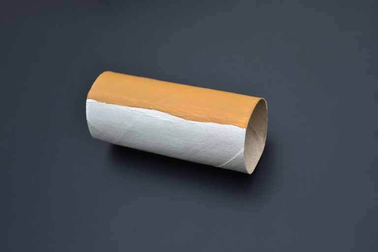 Un rouleau de papier toilette peint en blanc en bas, et en beige en haut.